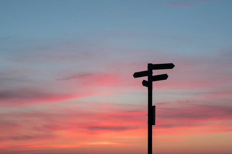 Silhouette von Straßenschildern während der goldenen Stunde Silhouette von Straßenschildern während der goldenen Stunde